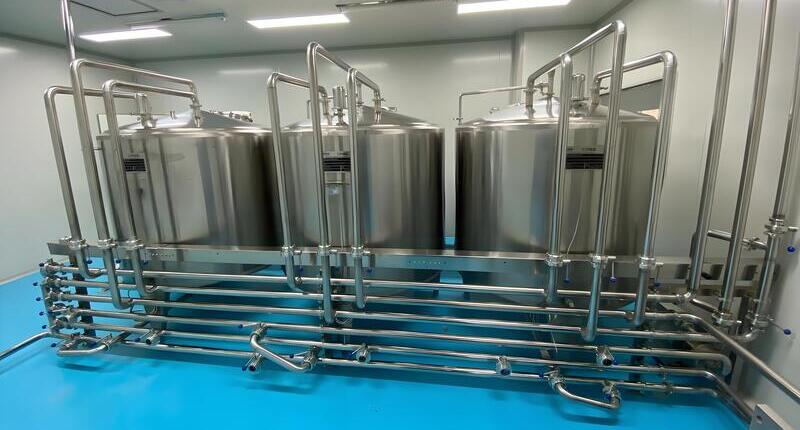 Automated 3-tank CIP cleaning system with sanitary stainless steel pipeline matrix for dairy processing line plants.