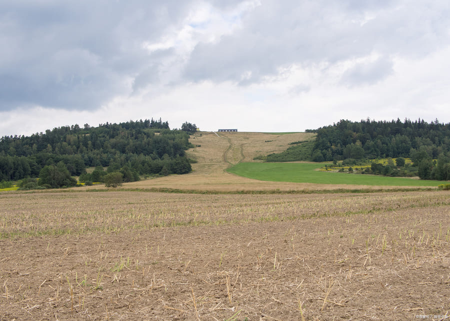 A large, flat field designated for dairy farm construction.