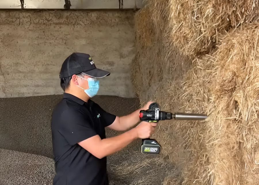 Using a hay probe to sample a round bale