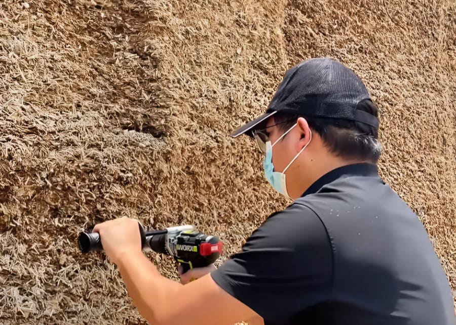 A farmer using a silage probe on a silage face