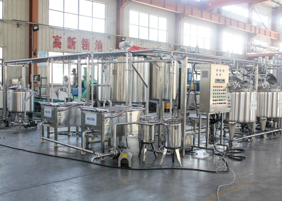 Industrial butter production line with melters, mixers, and automated control system.
