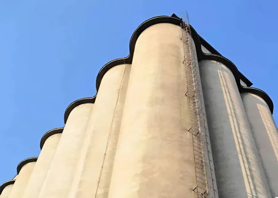 A tall blue tower silo on a large dairy farm