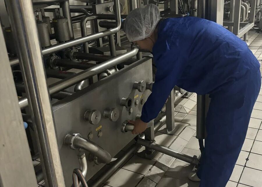 Technician connecting swing bends on a sanitary CIP flow select panel in a dairy plant