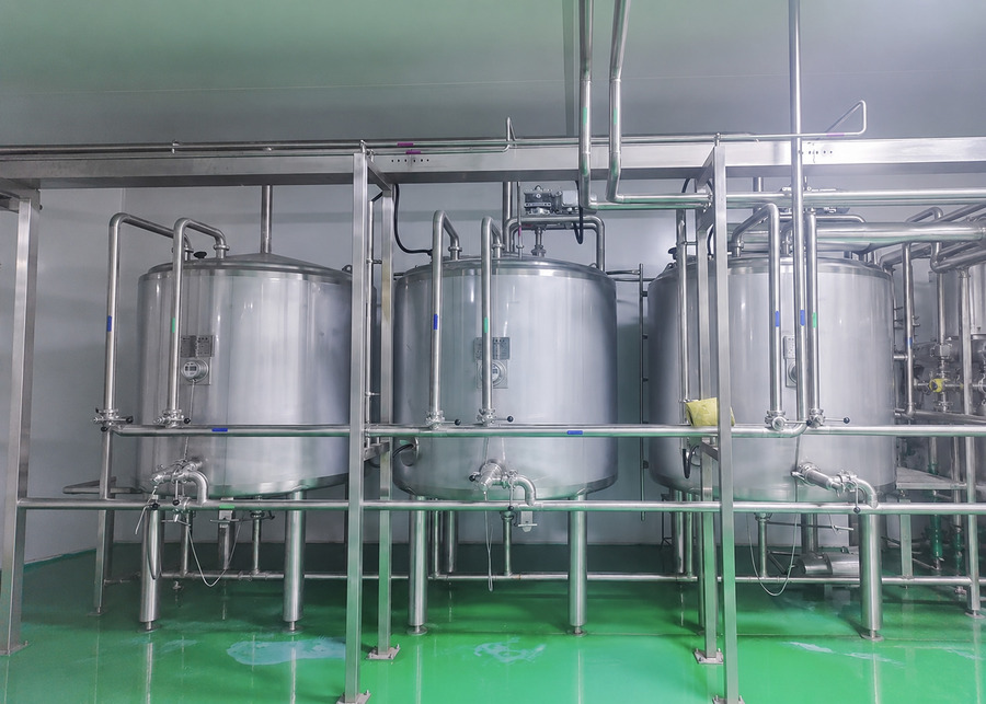 Industrial vertical stainless steel cooling tanks in a professional yogurt production line