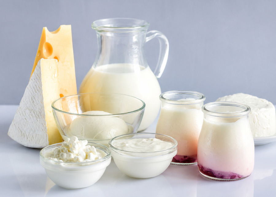 Strategies for Dairy Aroma A glass pitcher of fresh milk surrounded by cheese and yogurt cups - Dairy Aroma Improvement