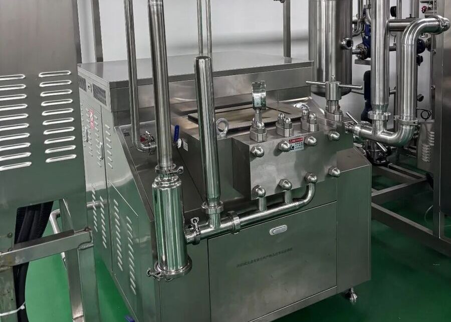 Milk Preheating and Homogenization Equipment Stainless steel high-pressure homogenizer connected to a preheating plate system in a dairy processing line