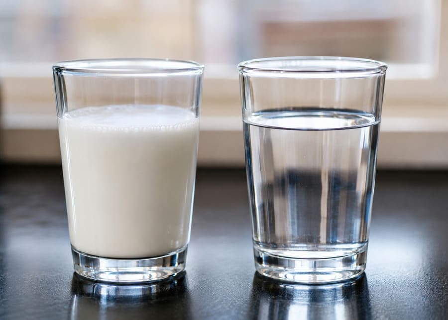 a glass of milk next to a glass of water